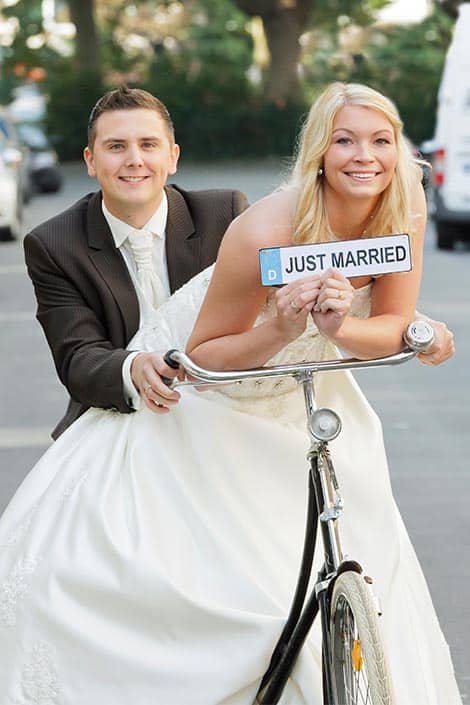 Hochzeitsfotograf fotografiert das Brautpaar mit einem Fahrrad - schöne Hochzeitsfotos